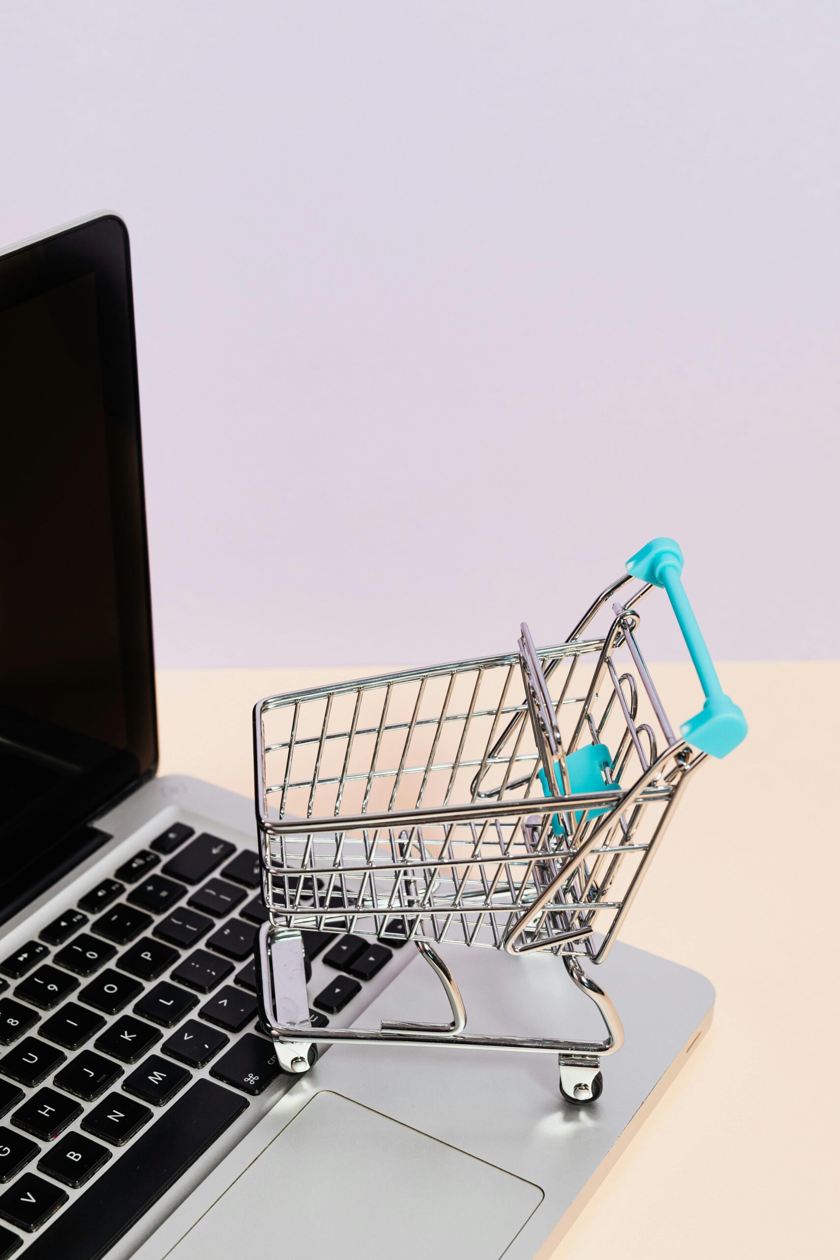 Mini shopping cart on a laptop symbolizes online shopping and e-commerce themes.